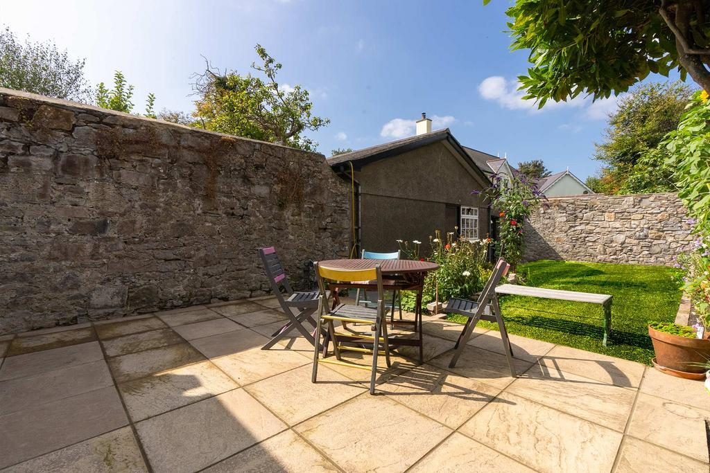 The walled courtyard garden, fully enclosed, with lawn and seating